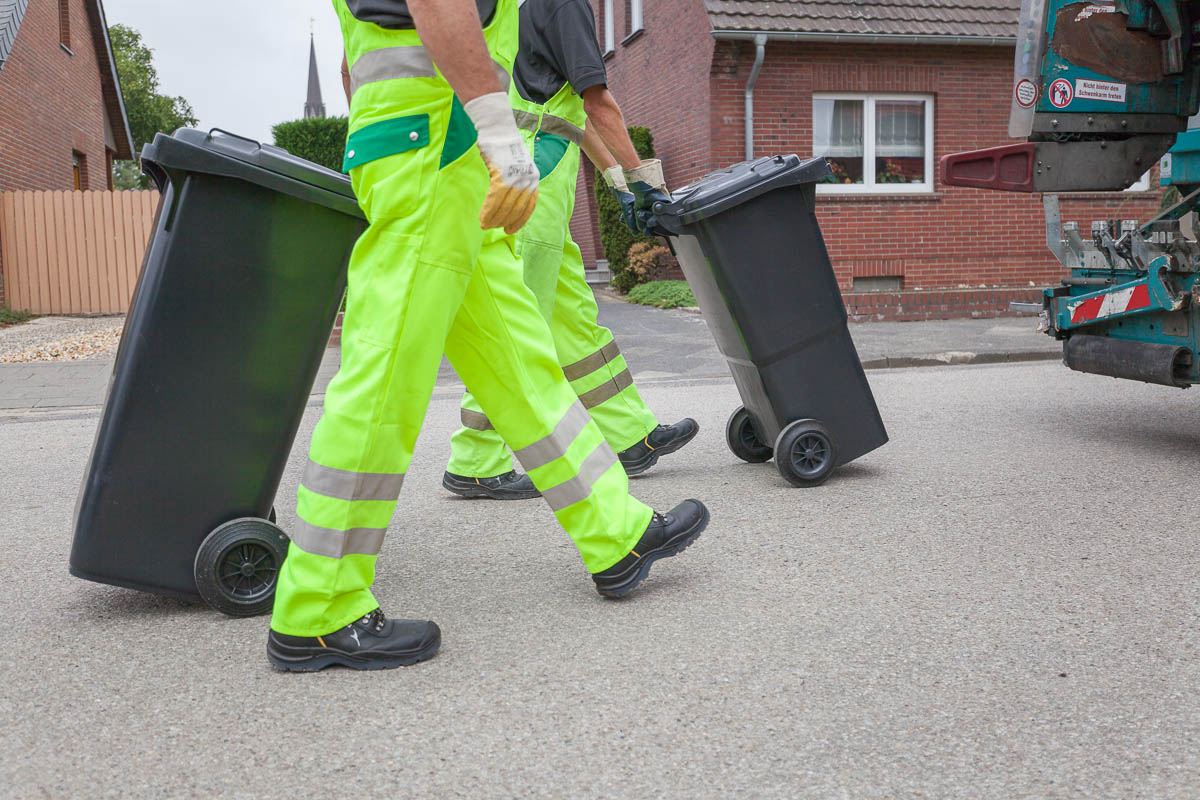 Müllwerker leeren Restmülltonne.