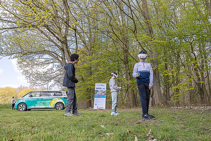 Schüler*innen testen mit VR-Brillen eine XR-Anwendung im Stadtwald.
