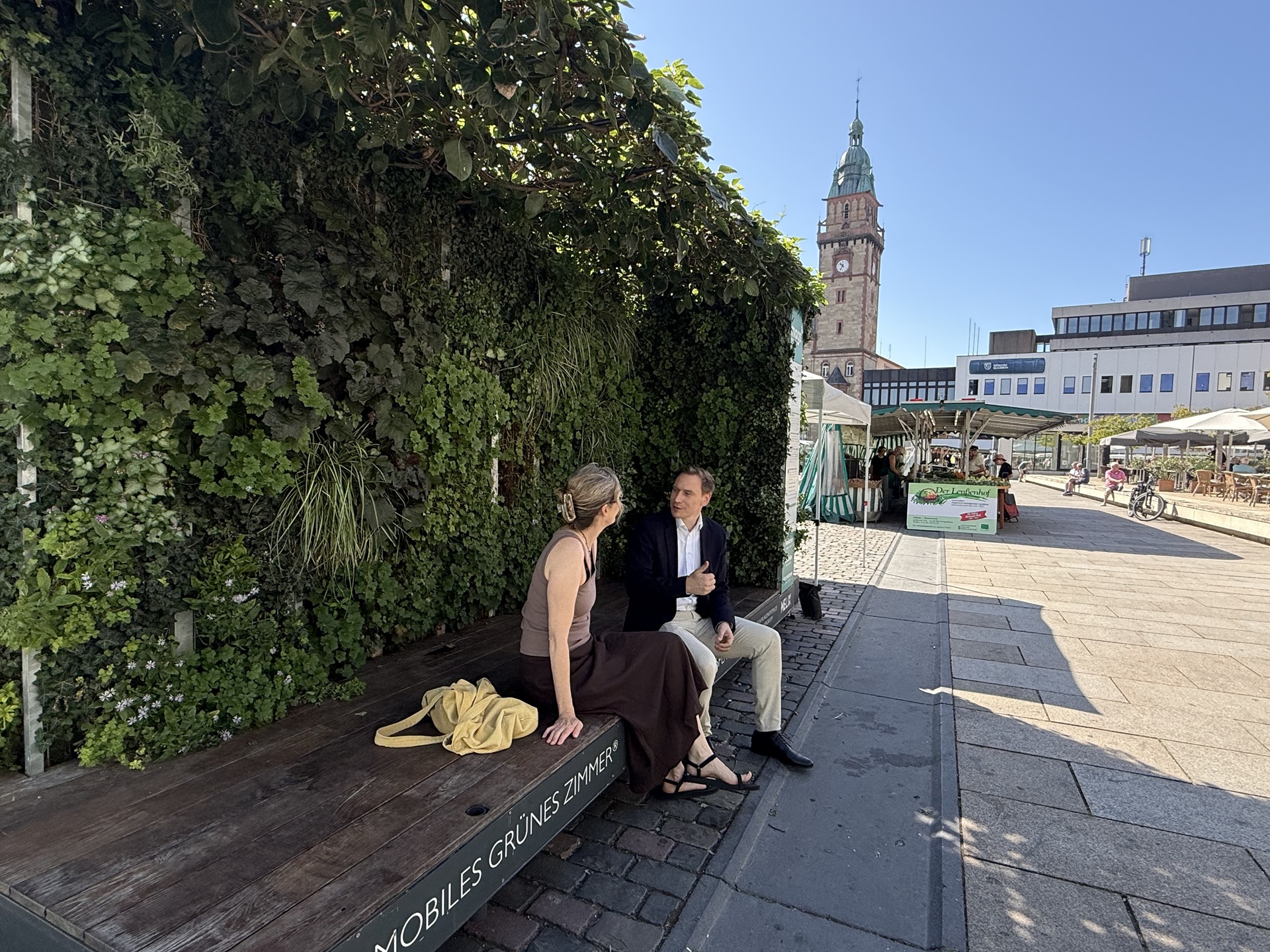 mags-Vorstand Jens Hostenbach spricht mit Markt-Besucherinnen über das „Mobile Grüne Zimmer“.